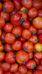 a pile of tomatoes on the market, the color is red and tomatoes can be use as complementary food or made for sauce. and the photo can be use as texture and background.