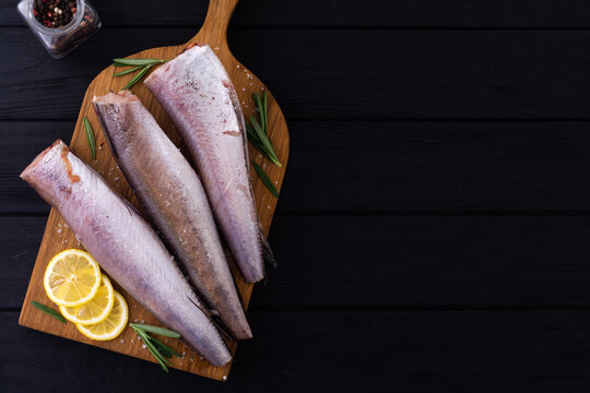 Raw hake on wooden background