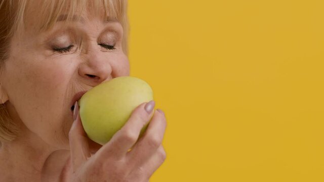Strong Healthy Teeth. Happy Senior Woman Biting Fresh Apple And Smiling