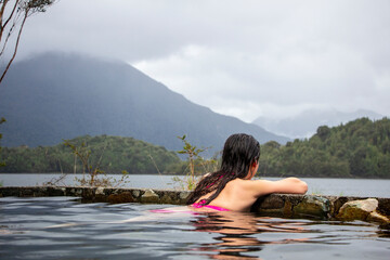 Woman in hot springs, southern Chile. Austral road. Hot waters that come out of the volcano on an island in the sea. 