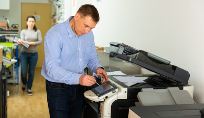 Worker is printing a file, document in the office room. High quality photo