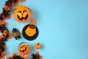 Creative flat lay of various Halloween decoration on blue background with copy space