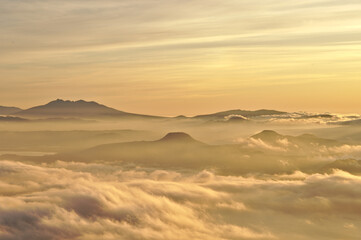 Fototapeta na wymiar 山々のシルエットと雲の幻想的な風景。