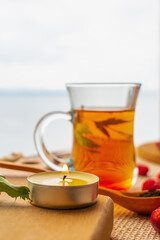 Black tea and rose hips on the background of a cloudy sky