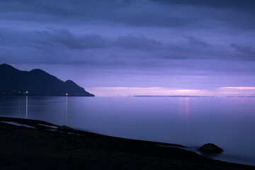 relaxing purple view of the lake llanquihue beach in a cloudy sunset
