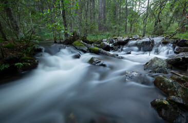 Wild river running through a forest in dalarna, Sweden photographed with long exposure 