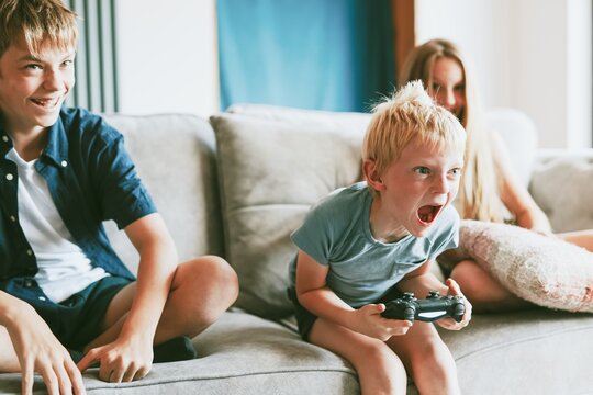 Blond boy playing video game in living room