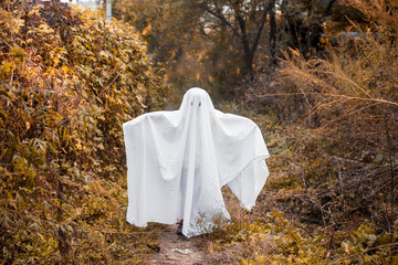 Little girl dressed as a Halloween ghost. Child is having fun on Halloween in a ghost costume.