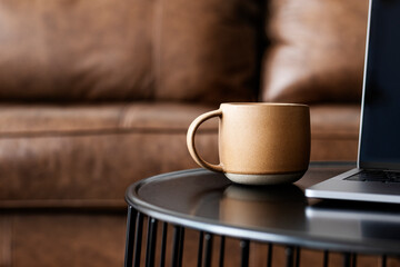 Cup of coffee by a laptop