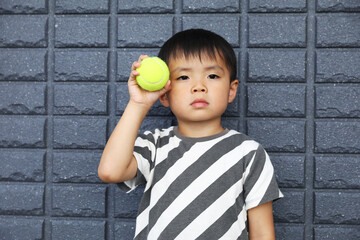 テニスボールを持った男の子。
