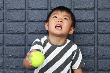 テニスボールを持った男の子。