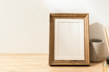 Blank decorative picture frame on wooden table