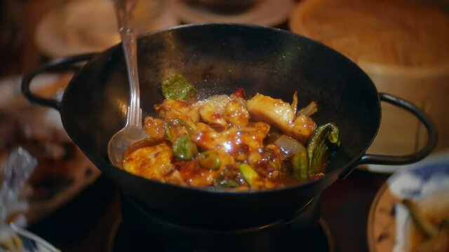 Sizzling Chinese chili chicken stir fry in iron wok