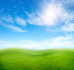 Fototapeta na wymiar Green grass hills under blue sky.