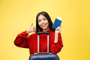 Woman travel. Young beautiful asian woman traveler with passport and suitcase on yellow background