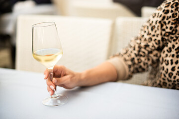 Glass of white wine in the hand of anonymous woman