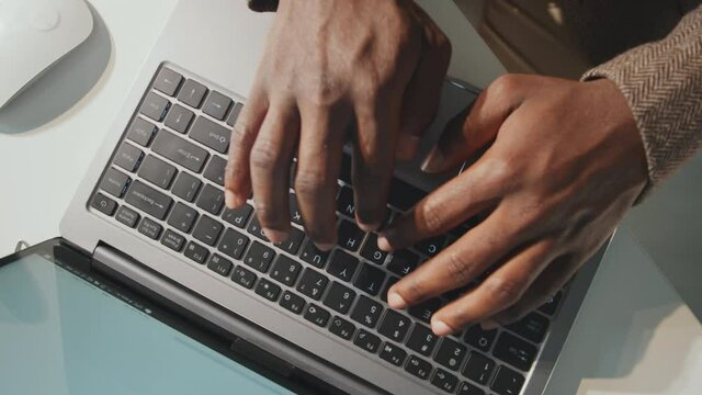 Horizontal From Above View Close-up Shot Footage Of Unrecognizable Black Mans Hands Typing Text On Laptop Keyboard