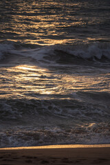 The sea waves were lapping towards the shore as the sun was setting, in this picture the light was moody and there was a darker part than the bright part.