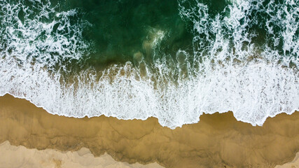 The sea waves that are hitting the shore Taken from a high angle with a drone