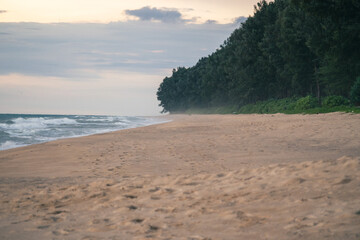 Footprints on the sandy beach and the sun is going down