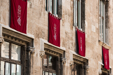 Valencian community coat of arms heraldry on a bordeaux flag in the government building with gothic style.