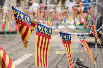Flags of Valencia with firecrackers in the background ready for the "mascletá".