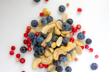 Full frame closeup forest fruit fresh berries colorful assorted large mix in studio on white background. Isolated yummy food pattern of Peanuts, cashews, domesticated, wild blueberries, lingonberries 