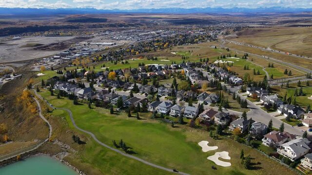 Aerial top down view of houses and streets in beautiful residential neighborhood in North America. Real estate, drone shots, sunset, sunlight. View from above on houses in Cochrane, Alberta, Canada.