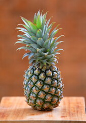 Fresh pineapple on wooden floor isolated in brown background