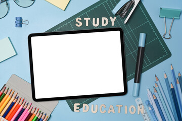 Mock up digital tablet with empty screen and various stationery on blue background. Back to school concept.