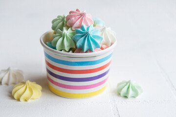 Small colorful meringues in the  paper bowl