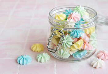 Small colorful meringues in the glass jar