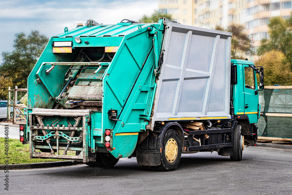 Poster a garbage truck picks up garbage in a residential area. separate collection and disposal of garbage.
