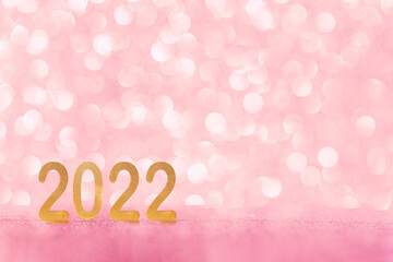 Christmas and 2022 New Year abstract background with shiny gold glittered bokeh. Festive greeting card