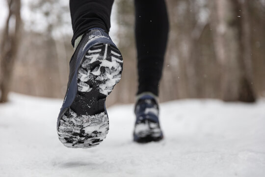 Winter Exercise Fitness Lifestyle Athlete Walking With Running Shoes On Snow And Slippery Ice Needing Traction Soles On Icy Sidewalks. Run Outside In Cold Weather.