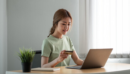 Happy woman doing online shopping at home, woman hand holding credit card and using laptop computer