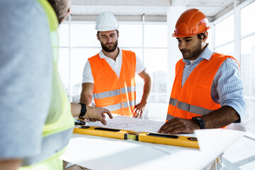 Two engineers man looking at project plan on the table in construction site