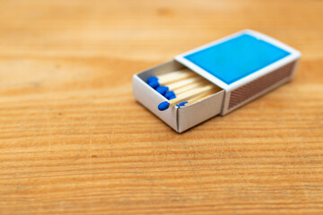 Matches in box on wooden background. Closeup shot. Matchsticks in open match-box flat lay.Matches in open match-box on a carton underlay.Selective focus.Copy space.