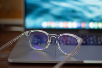 transparent eyeglasses on a gray laptop 