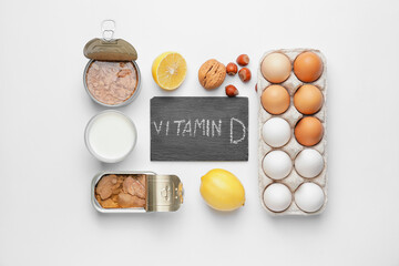 Text VITAMIN D and different healthy products on white background