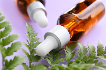 Bottles of healthy essential oil on color background, closeup