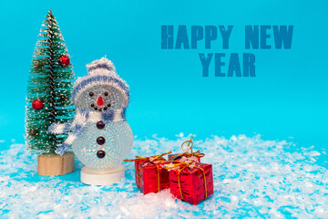 Happy New Year inscription snowman on a blue background with presents.Front view.