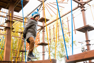 Little boy plays in the rope park.