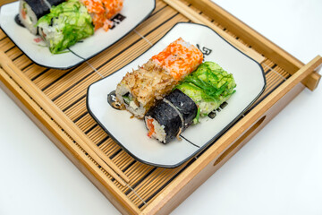Several sushi on a white plate standing on a white background
