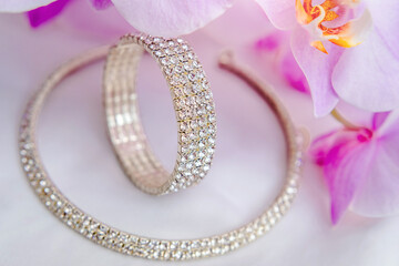 Bracelet and necklace on white fabric and purple Orchid