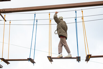 Little boy plays in the rope park.