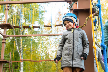 Little boy plays in the rope park.