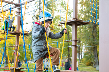 Little boy plays in the rope park.