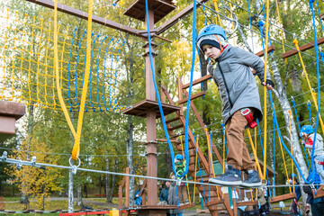 Little boy plays in the rope park.