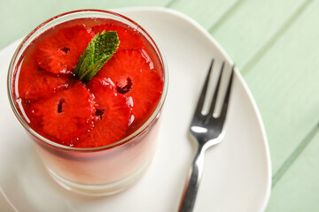 Glass with tasty strawberry panna cotta and mint on table, closeup